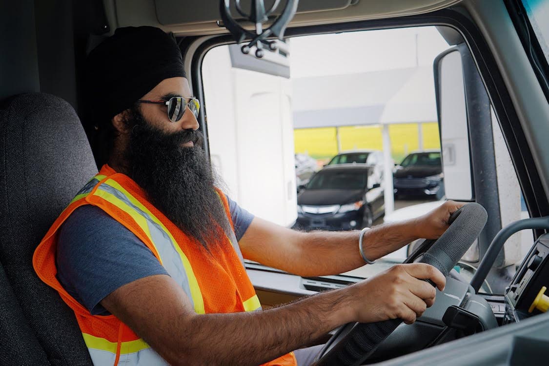 Commercial truck driver seated behind the wheel of his cab